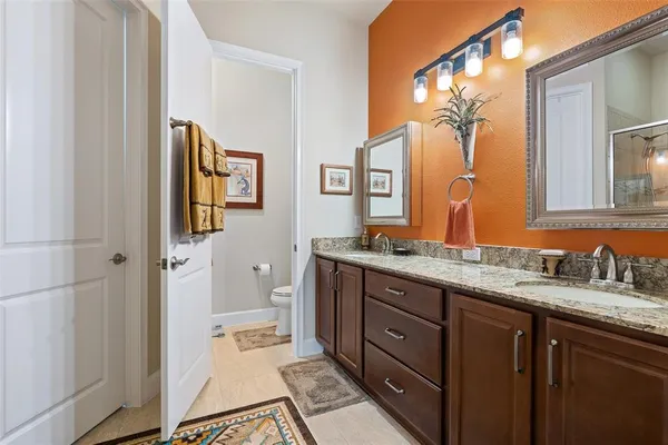 a spacious bathroom with a granite countertop sink and a mirror