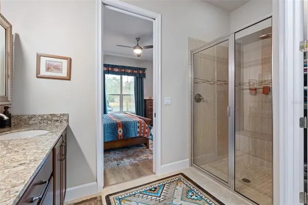 a bathroom with a granite countertop sink a mirror and shower