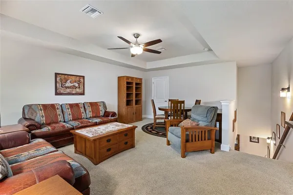 a living room with furniture and a ceiling fan