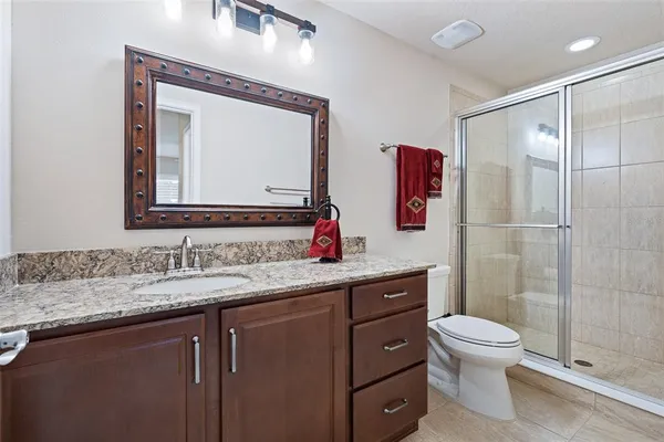 a bathroom with a sink vanity mirror and toilet