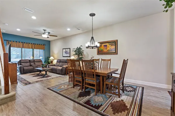 a view of a dining room with furniture a rug and wooden floor
