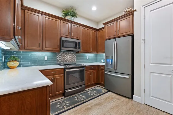 a kitchen with granite countertop a refrigerator stove and microwave