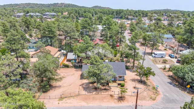 an aerial view of residential houses with outdoor space and trees