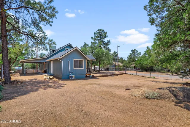 a view of house with yard and trees in the background