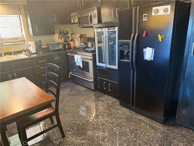 a kitchen with stainless steel appliances granite countertop a refrigerator and stove