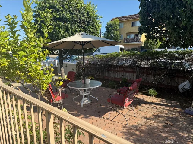 a view of a table and chairs under an umbrella in backyard