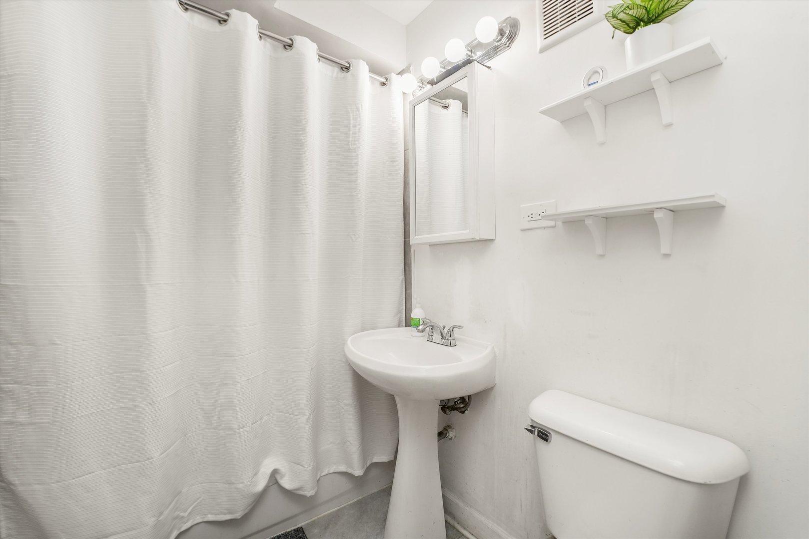 8119 South Paulina Street Chicago, IL 60620 - Photo 17 of 19 a bathroom with a sink a toilet and shower curtain