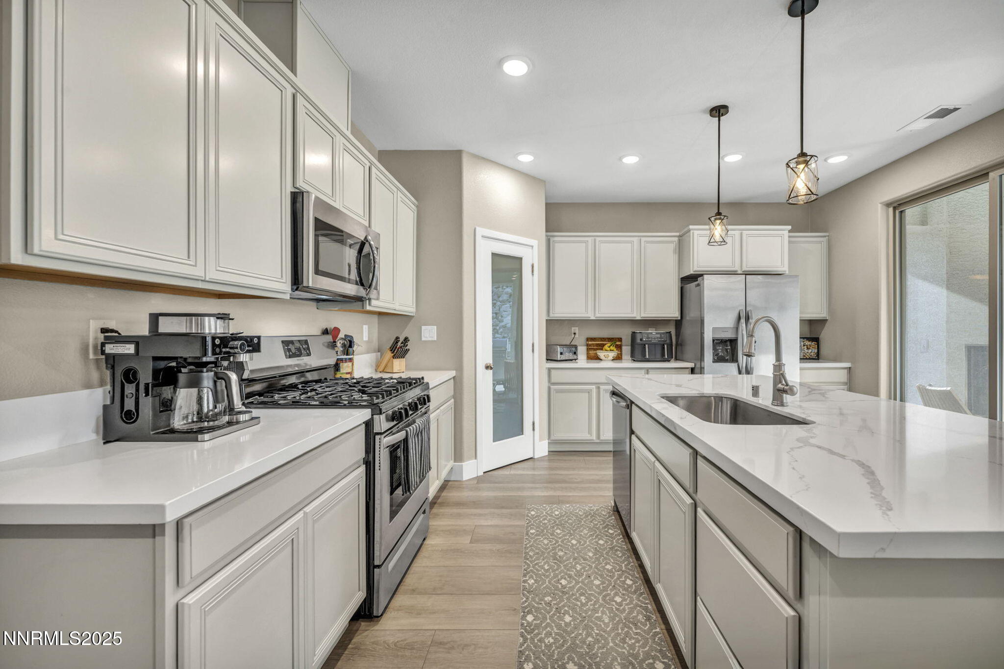 32 Stellar Court Carson City, NV 89705 - Photo 13 of 49 a kitchen with kitchen island granite countertop stainless steel appliances lots of counter space sink refrigerator and cabinets