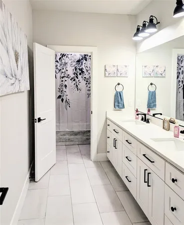 a bathroom with a double vanity sink toilet and shower