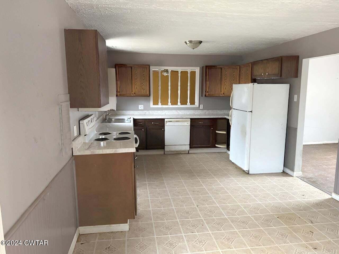 1759 Janes Mill Road Gleason, TN 38229 - Photo 9 of 18 a kitchen with a refrigerator a stove a microwave and cabinets