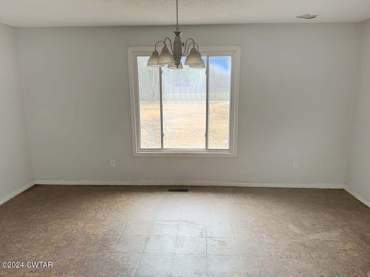 1759 Janes Mill Road Gleason, TN 38229 - Photo 10 of 18 an empty room with a windows and chandelier