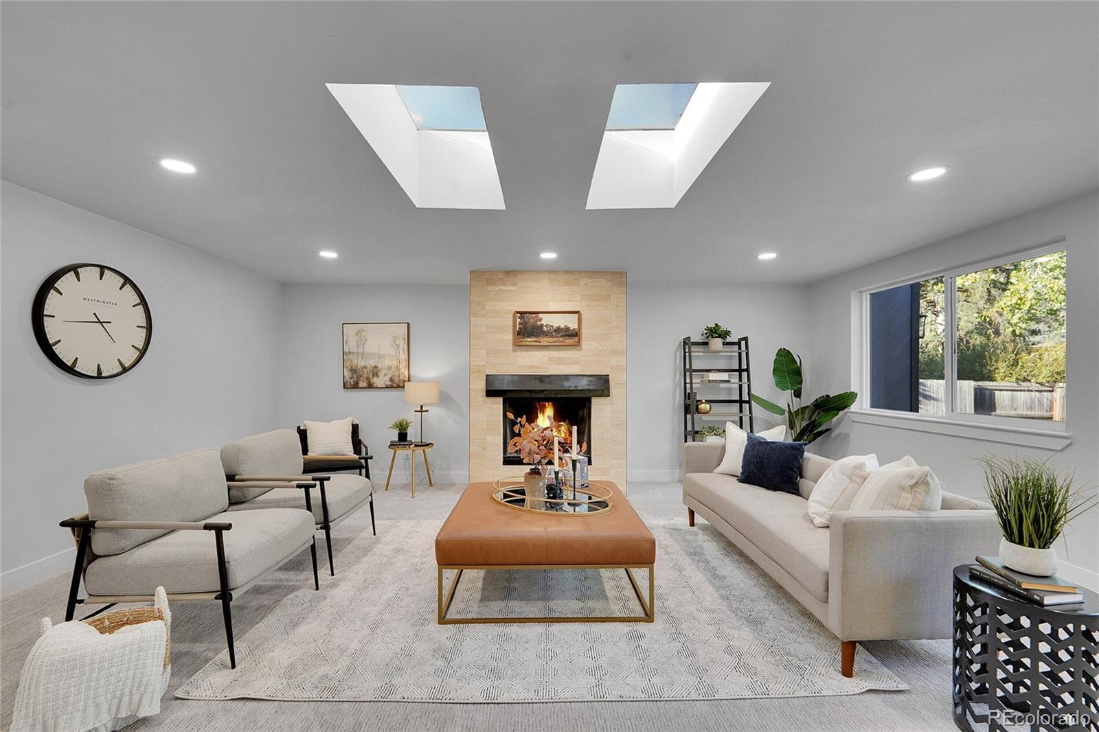 3261 South Oneida Way Denver, CO 80224 - Photo 15 of 43 a living room with furniture a clock on wall and a large window