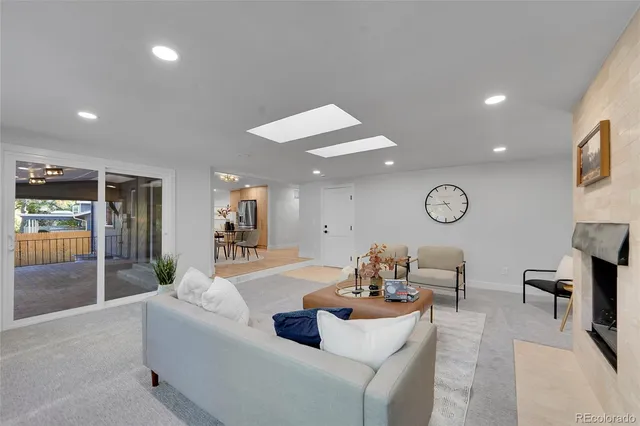 a living room with furniture kitchen view and a large window
