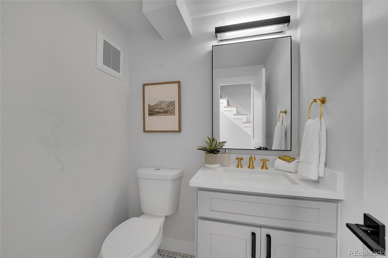 3261 South Oneida Way Denver, CO 80224 - Photo 18 of 43 a bathroom with a toilet sink and mirror