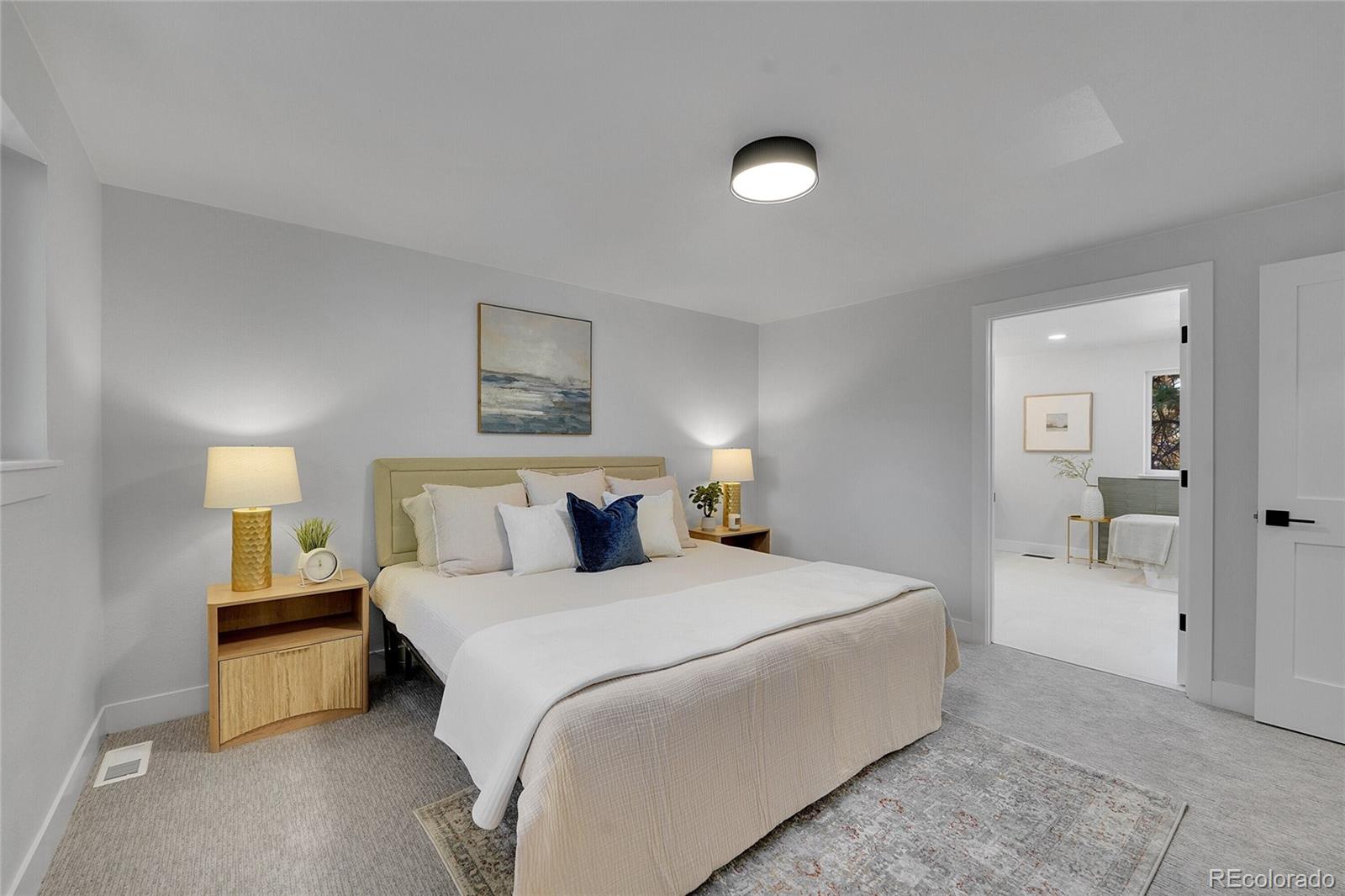 3261 South Oneida Way Denver, CO 80224 - Photo 20 of 43 a bedroom with a bed and a lamp