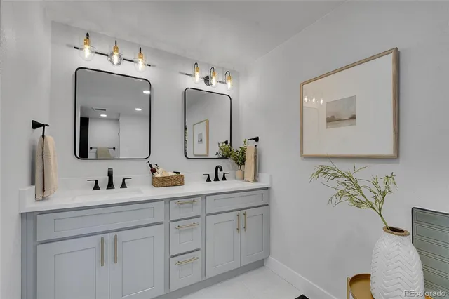 a bathroom with double vanity sinks and a mirror