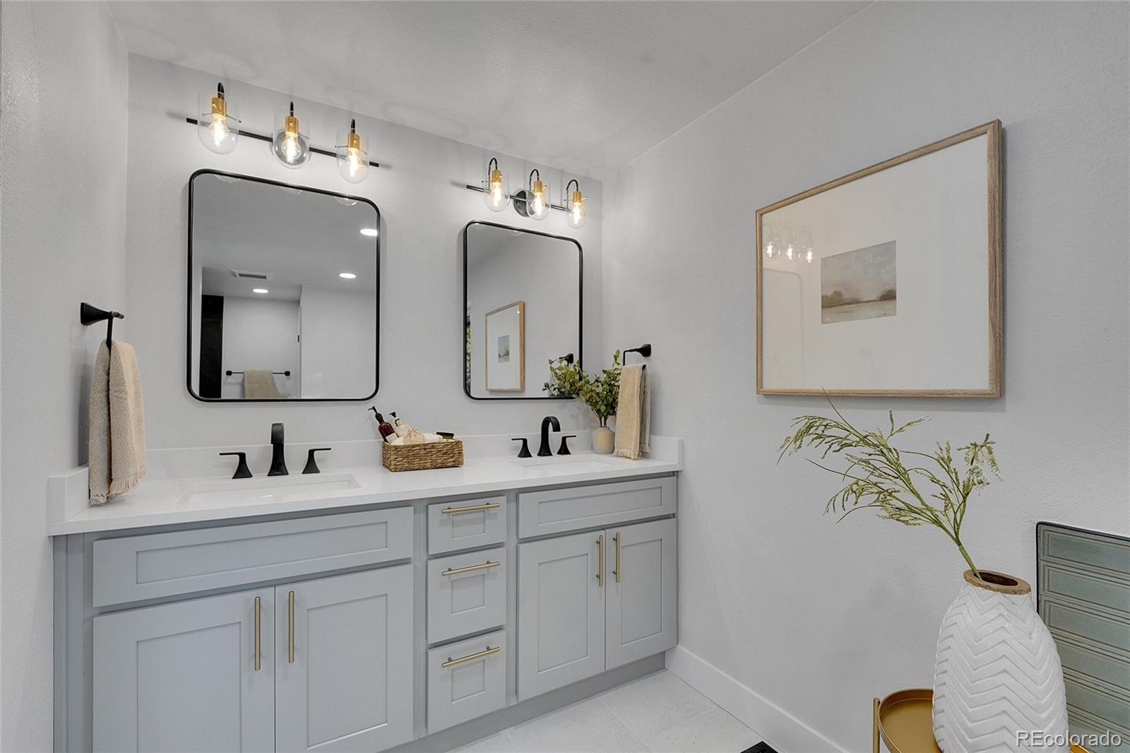 3261 South Oneida Way Denver, CO 80224 - Photo 23 of 43 a bathroom with double vanity sinks and a mirror