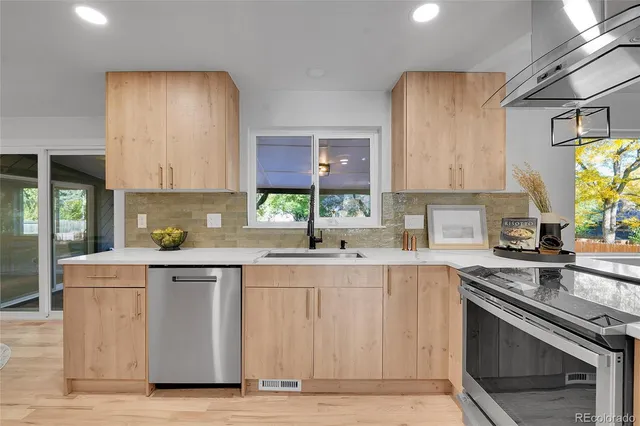 a kitchen with stainless steel appliances granite countertop a stove a sink and a microwave