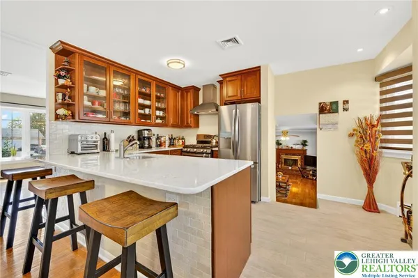 a kitchen with stainless steel appliances kitchen island granite countertop a refrigerator and a stove top oven