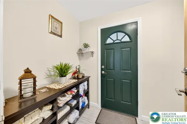 a view of front door with potted plant and a mirror