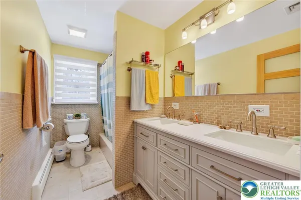 a bathroom with a double vanity sink toilet and mirror