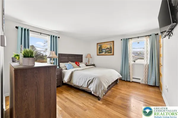 a bedroom with a bed and a potted plant on the dresser