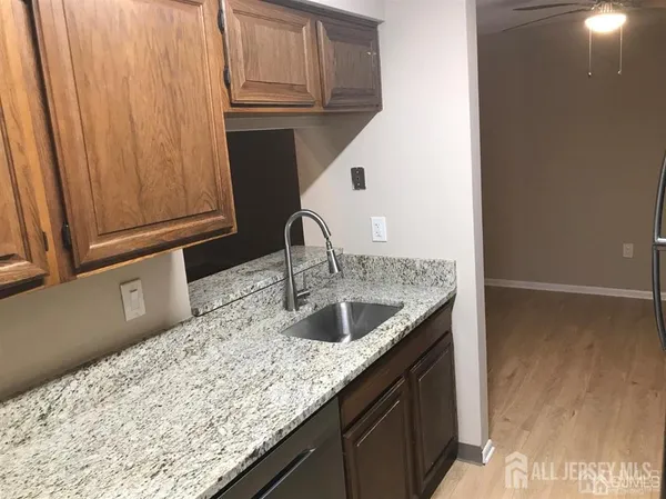 a kitchen with granite countertop a sink and a wooden cabinets