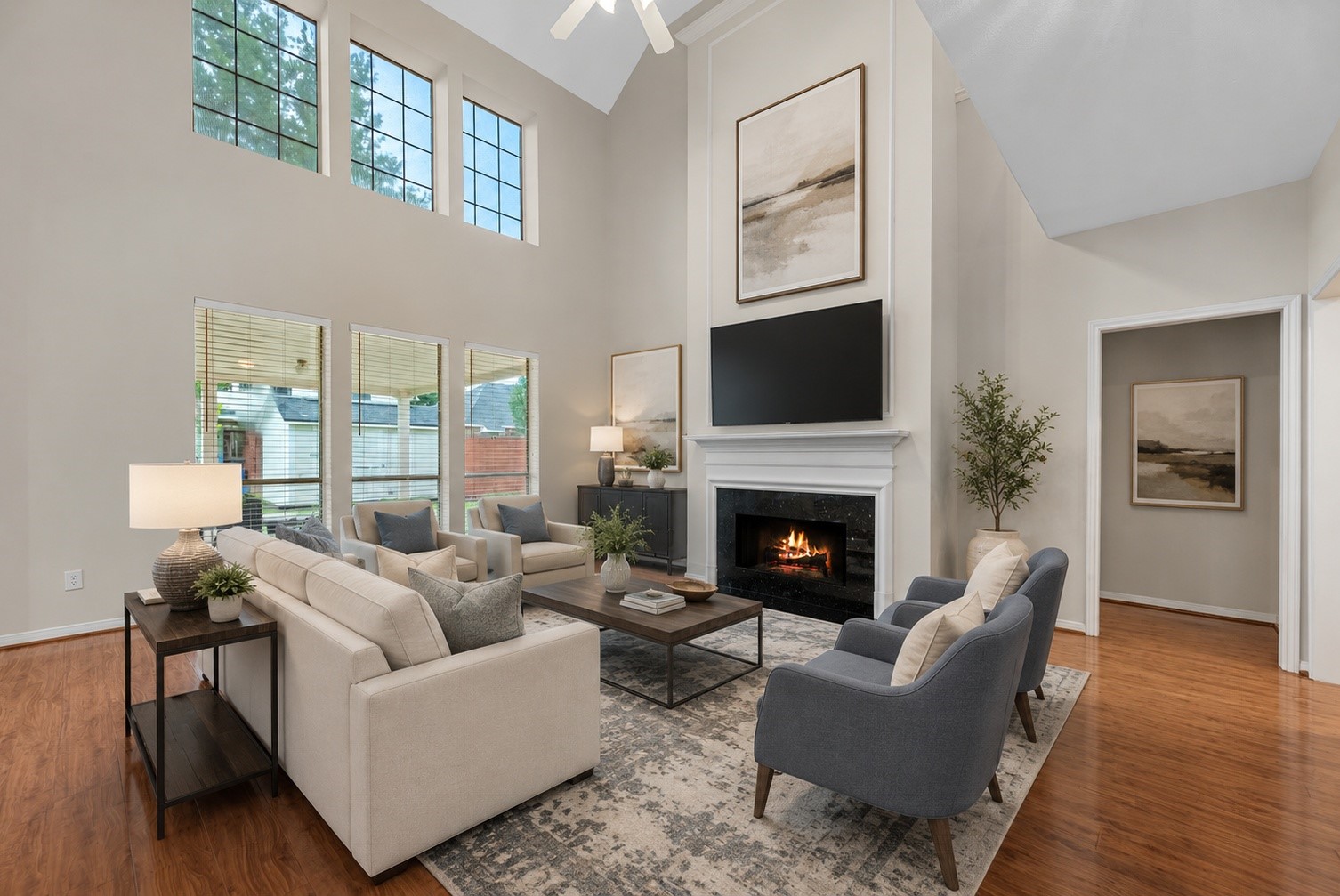 5724 Shady Hollow Court Rosharon, TX 77583 - Photo 9 of 27 Stunning two-story living room showcasing soaring ceilings, beautiful natural light, and a cozy fireplace as the focal point. Expansive windows frame the space while highlighting the warm wood flooring and open, airy layout. This inviting room offers exceptional potential for both everyday living and entertaining, with space for seating, a media setup, and elevated design touches that complement the home’s architectural charm. Photo features entry to primary suite.
Virtually staged to showcase potential.