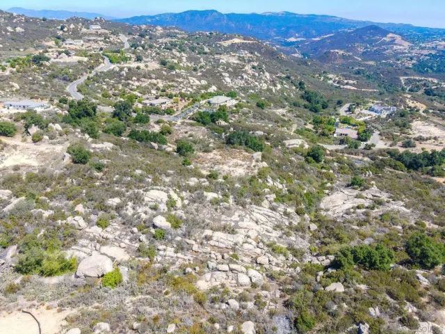 an aerial view of residential house with yard and mountain view in back