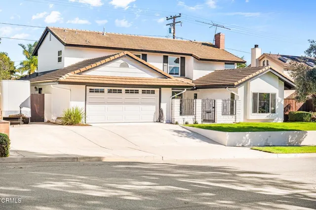 a view of a white house with a large windows and a small yard