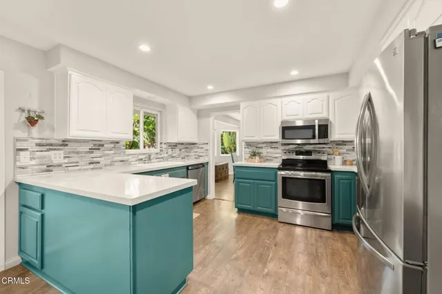 a kitchen with kitchen island white cabinets appliances and sink