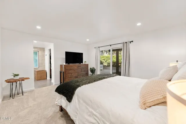 a bedroom with a large bed and a flat screen tv