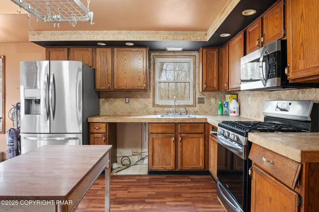 a kitchen with stainless steel appliances granite countertop a sink stove and refrigerator