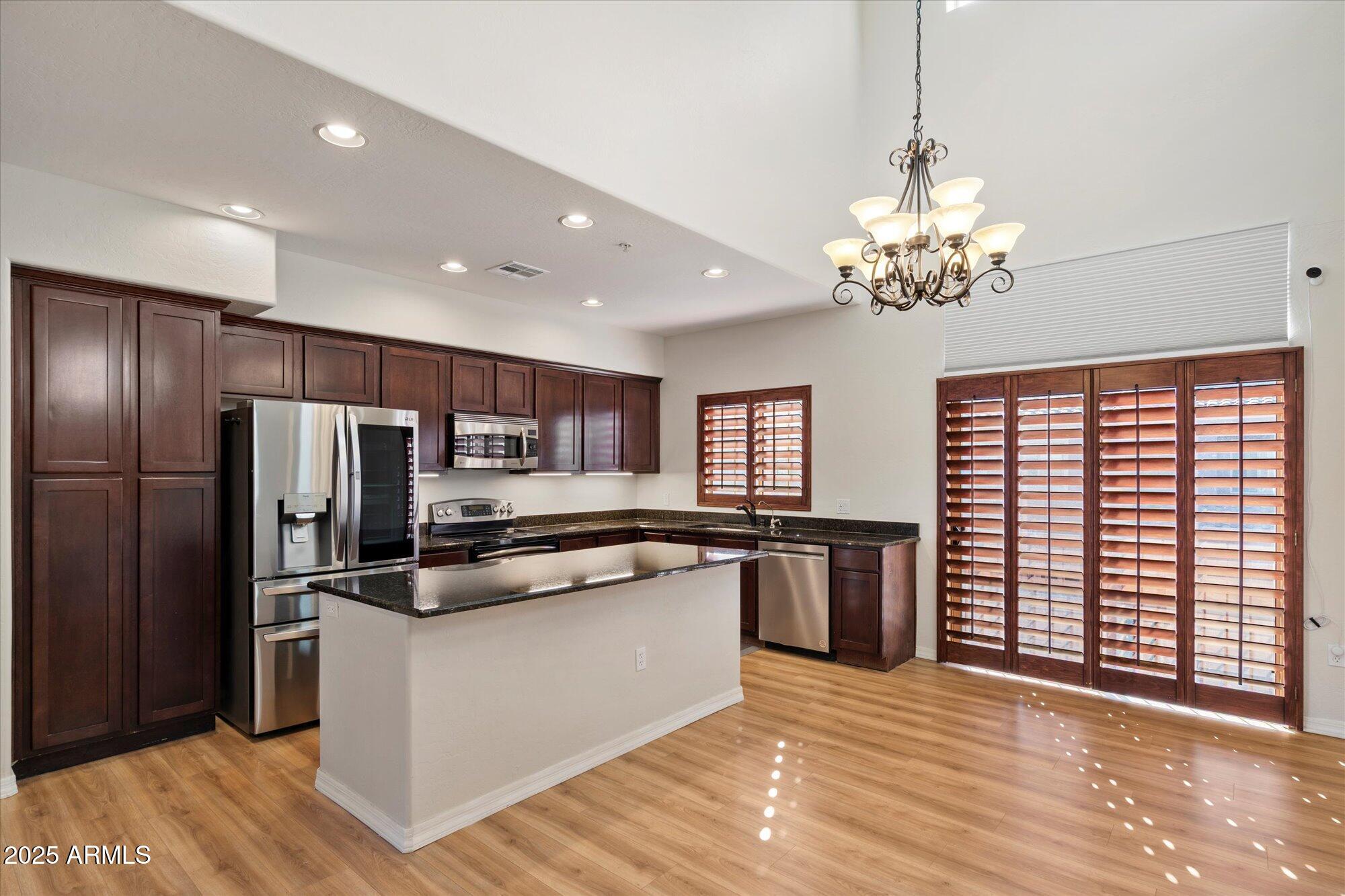 3935 East Rough Rider Road, Unit 1034 Phoenix, AZ 85050 - Photo 3 of 22 a kitchen with stainless steel appliances granite countertop a refrigerator and a stove top oven