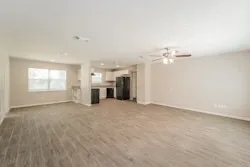an empty room with windows and chandelier fan