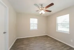 an empty room with a window and a fan