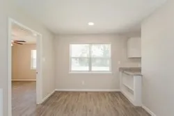 an empty room with a window and wooden floor