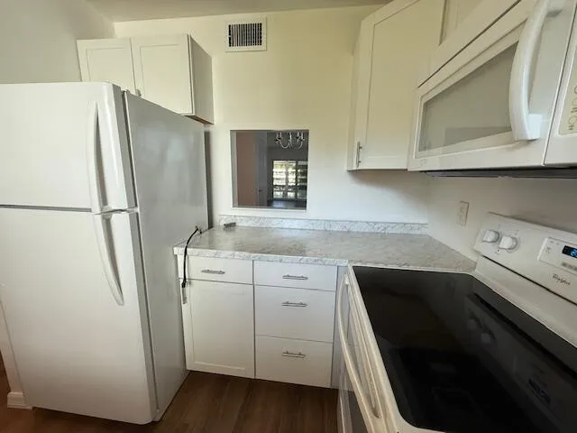 a kitchen with a refrigerator sink and cabinets