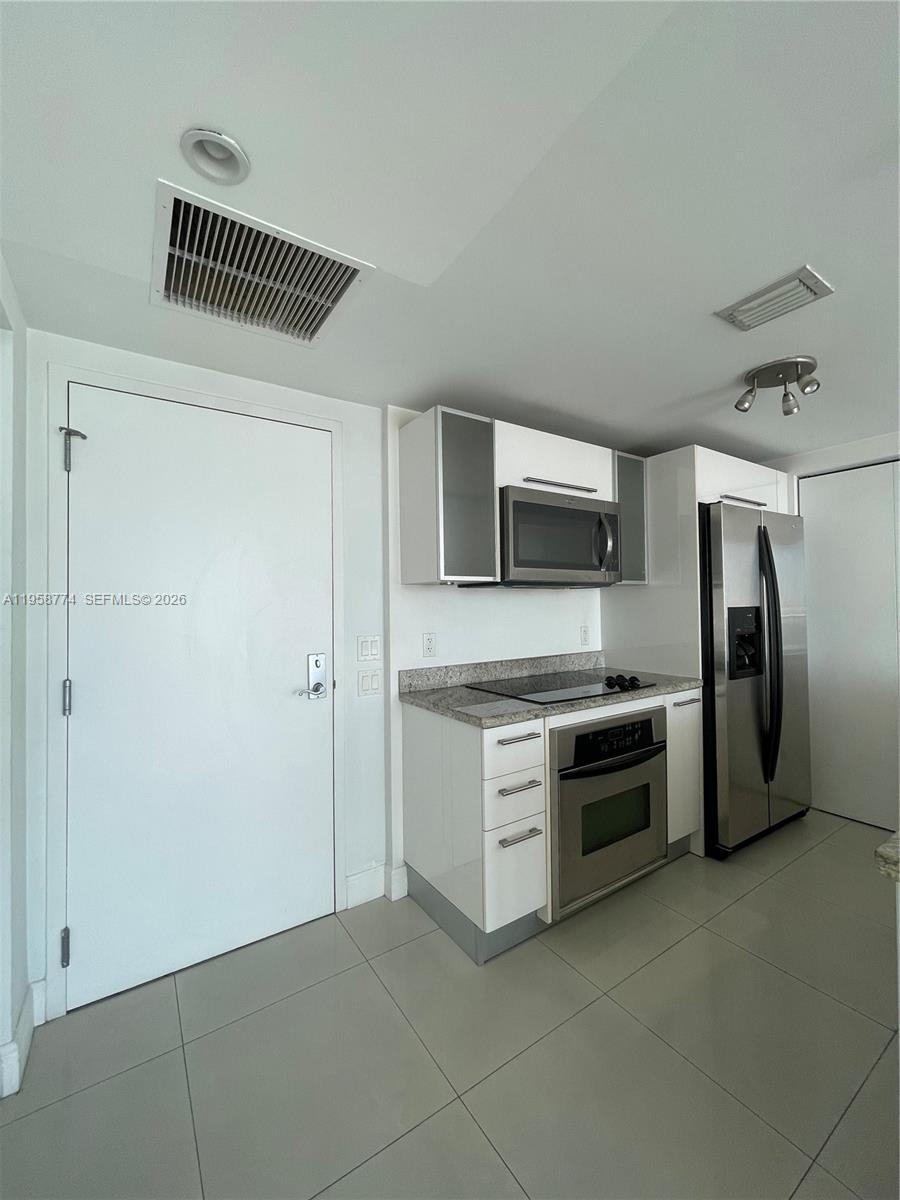 185 Southwest 7th Street, Unit 3810 Miami, FL 33130 - Photo 11 of 29 a kitchen with stainless steel appliances a refrigerator and a stove top oven