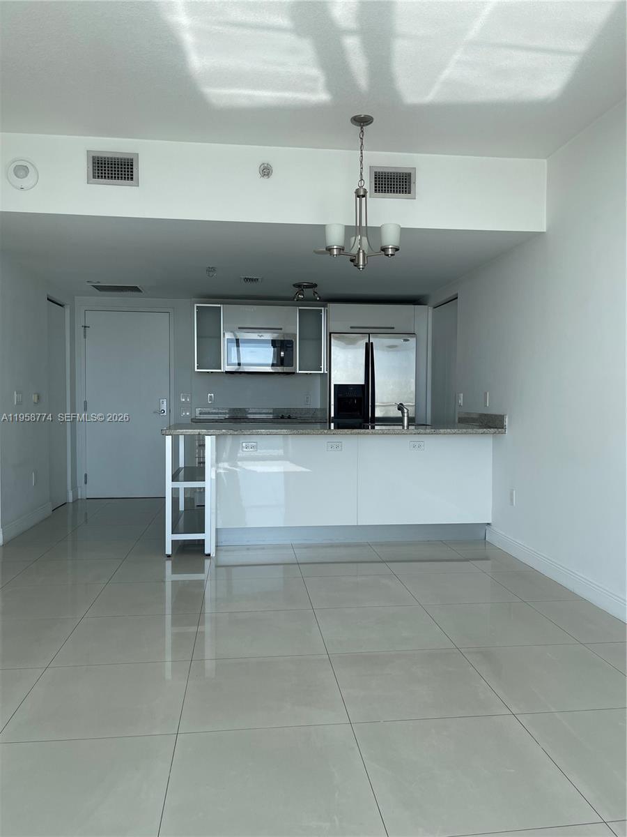 185 Southwest 7th Street, Unit 3810 Miami, FL 33130 - Photo 12 of 29 a view of a kitchen with a sink and a chandelier