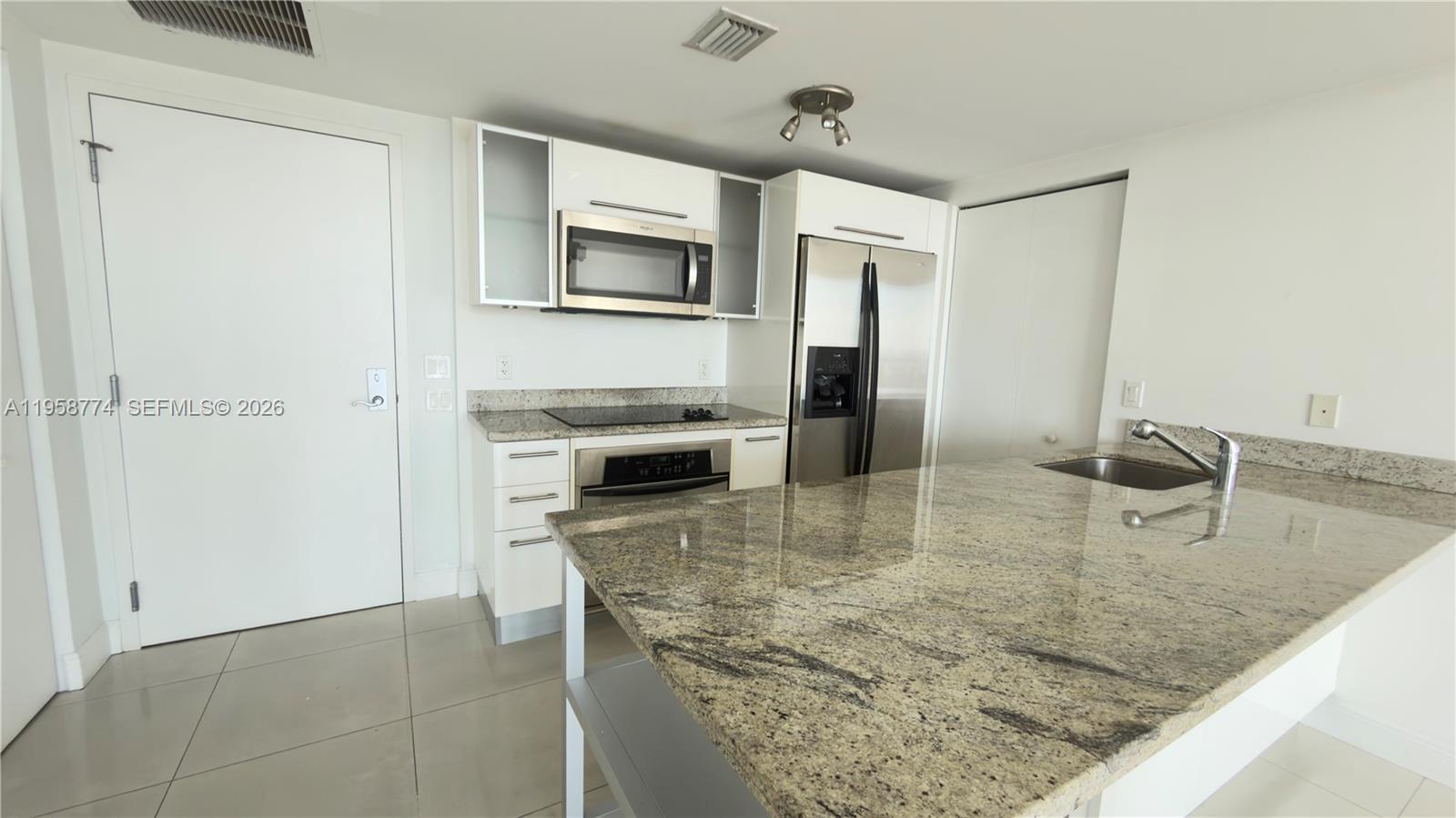 185 Southwest 7th Street, Unit 3810 Miami, FL 33130 - Photo 8 of 29 a kitchen with stainless steel appliances granite countertop a sink and a microwave