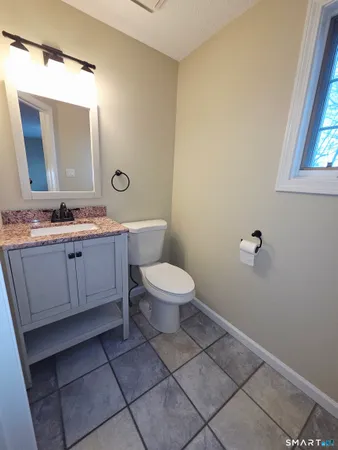 a bathroom with a toilet a sink and mirror