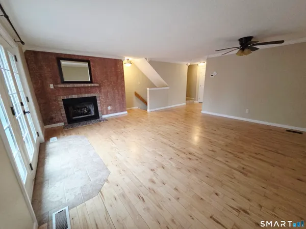 wooden floor fireplace and windows in an empty room