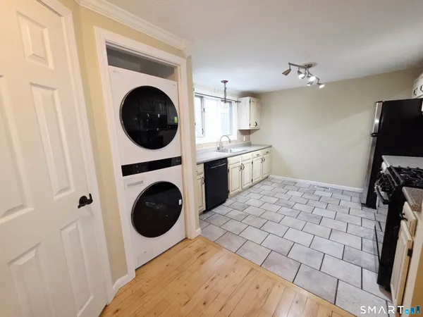 a view of a kitchen with washing machine and utility