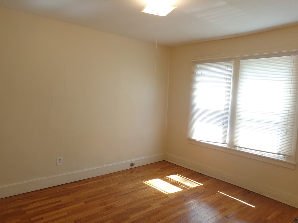 39-41 Ralph Street Springfield, MA 01109 - Photo 7 of 13 an empty room with wooden floor and windows