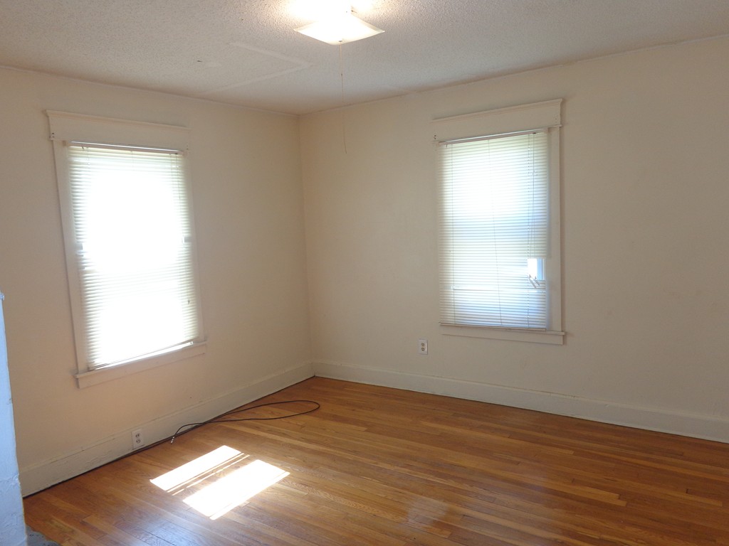 39-41 Ralph Street Springfield, MA 01109 - Photo 8 of 13 an empty room with wooden floor and windows