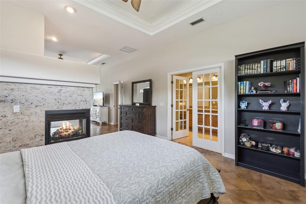 7139 Groveland Farms Road Groveland, FL 34736 - Photo 12 of 36 a spacious bedroom with a bed and a fireplace