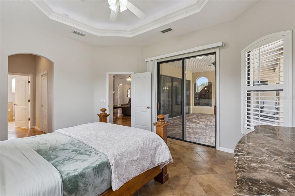 7139 Groveland Farms Road Groveland, FL 34736 - Photo 18 of 36 a bedroom with a large bed and a chandelier