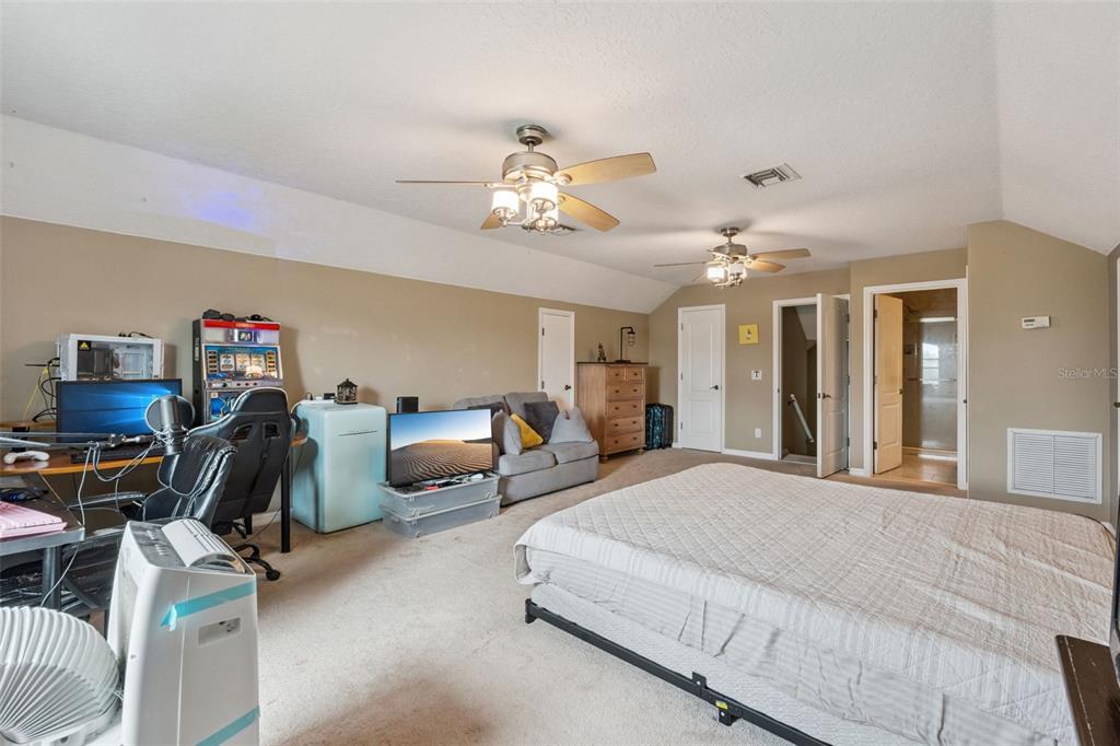 7139 Groveland Farms Road Groveland, FL 34736 - Photo 20 of 36 a bedroom with furniture and a chandelier