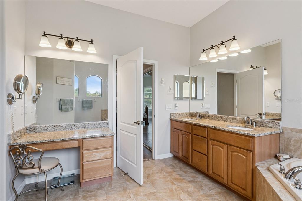 7139 Groveland Farms Road Groveland, FL 34736 - Photo 21 of 36 a spacious bathroom with a granite countertop sink mirror and shower
